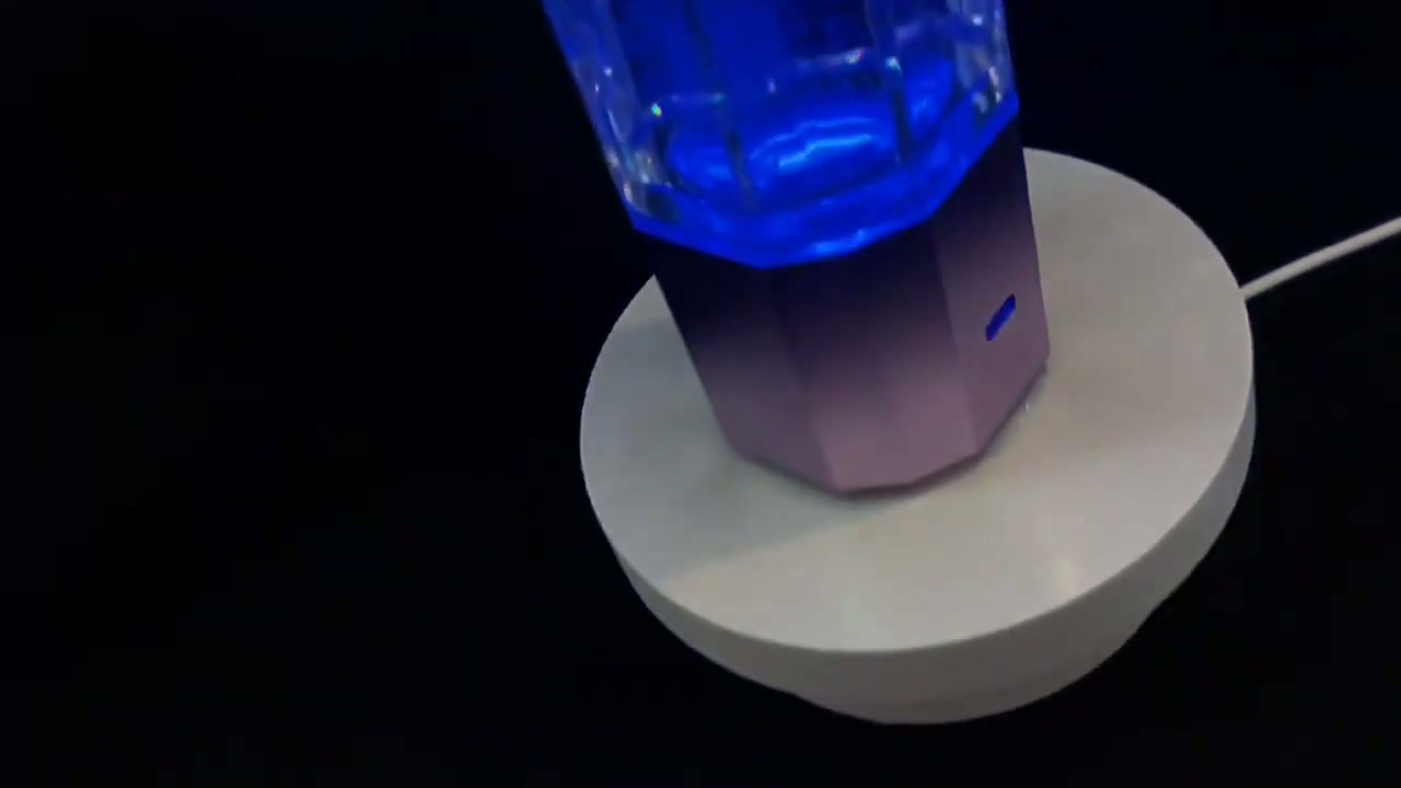 QY01 base ring lit blue beneath the glass bottle